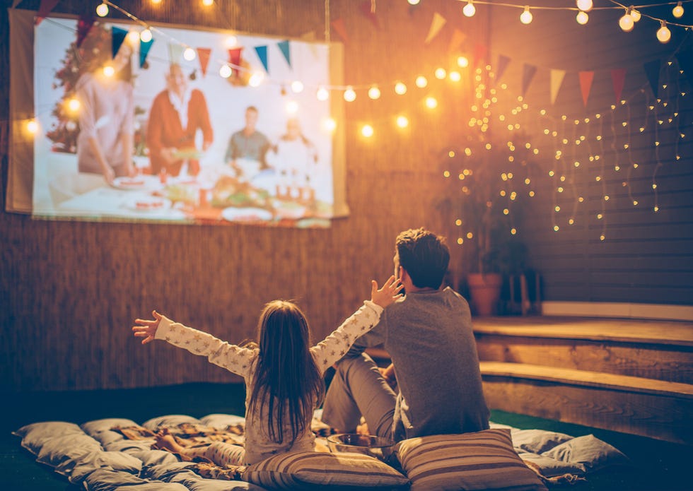 father and daughter backyard movie night in the fall