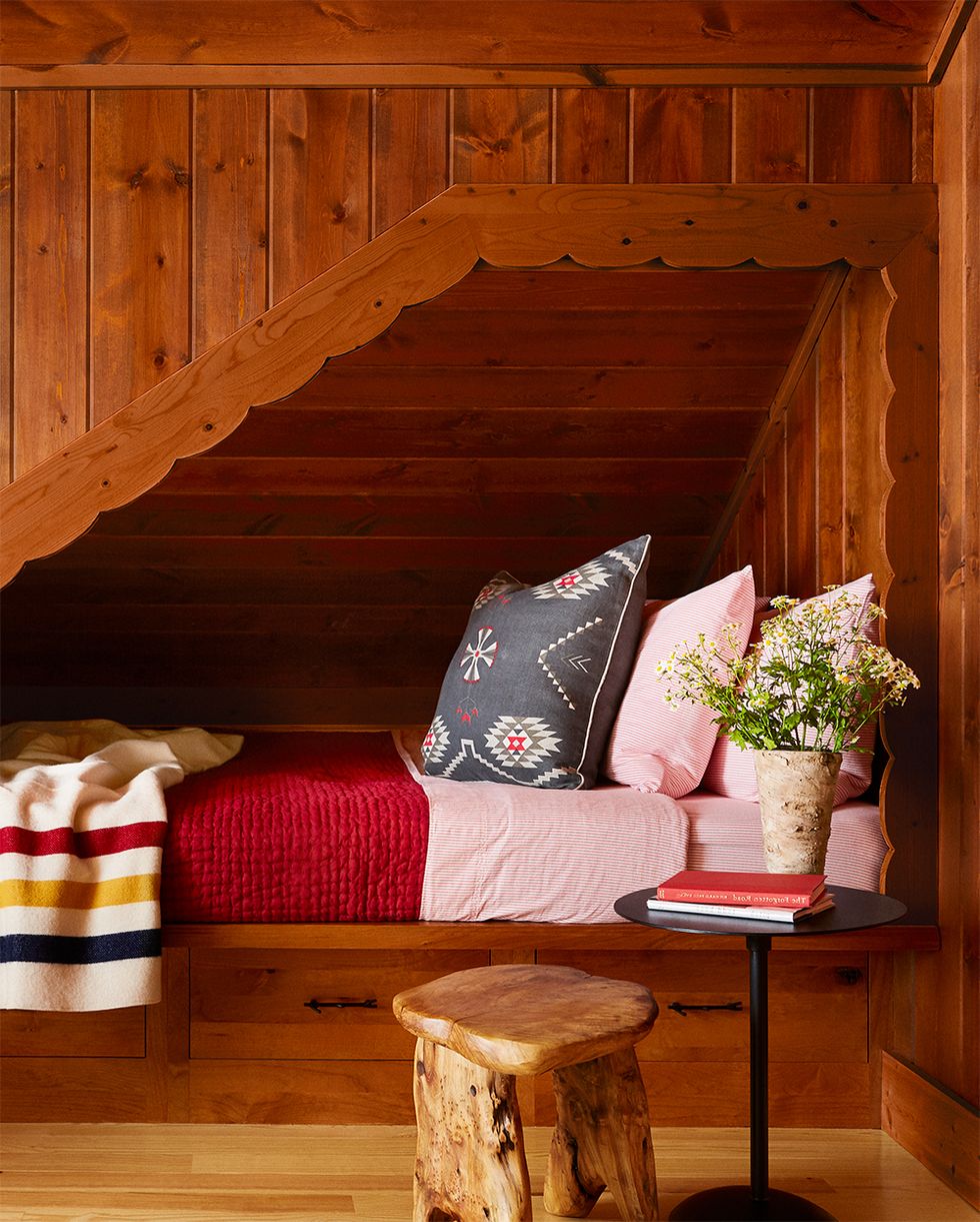 cozy wood paneled reading nook with scallop trim and red and blue bedding