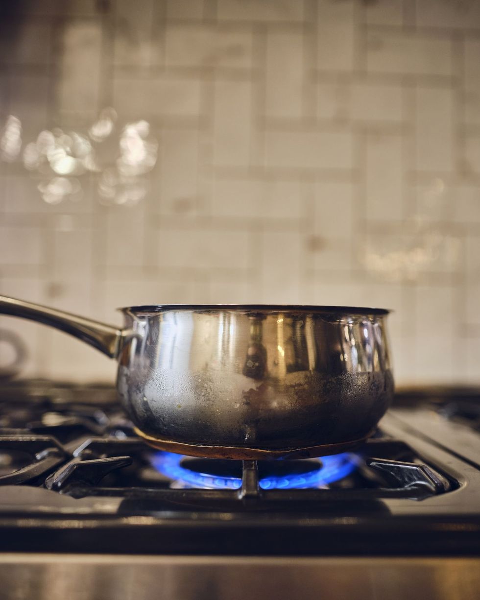 a gas ring burns on a home stove for simmer pot fall activity