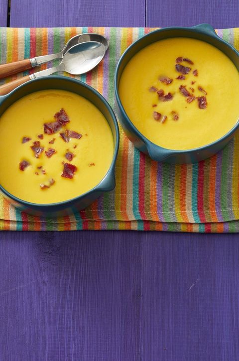 butternut squash soup with bacon with purple wood background