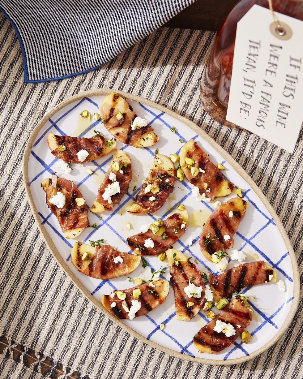 grilled apples with prosciutto and honey arranged on an oval serving tray