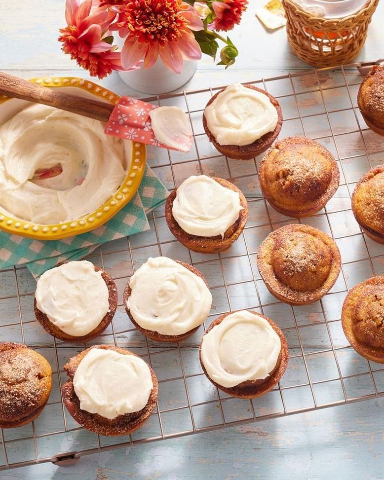 pumpkin spice muffins with cream cheese frosting on wire rack