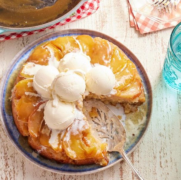 apple cake in an iron skillet with ice cream on top