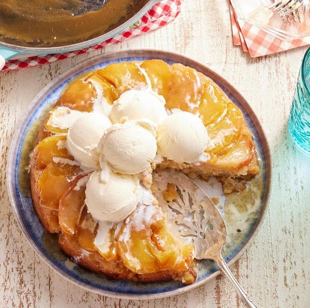 apple cake in an iron skillet with ice cream on top