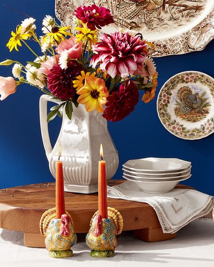 collection of thanksgiving turkey plates and platters and flowers in a pitcher