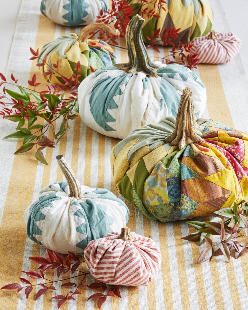 fabric pumpkins line the center of a fall table