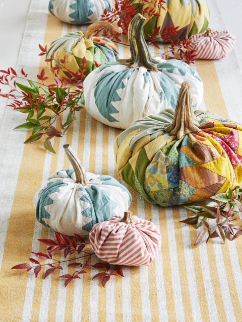 fabric pumpkins line the center of a fall table