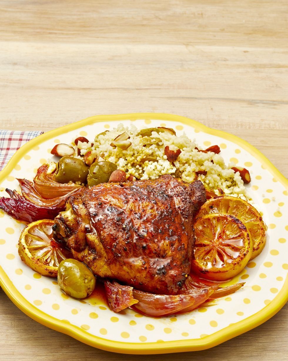 sheet pan chicken with lemons and olives on yellow plate with cous cous
