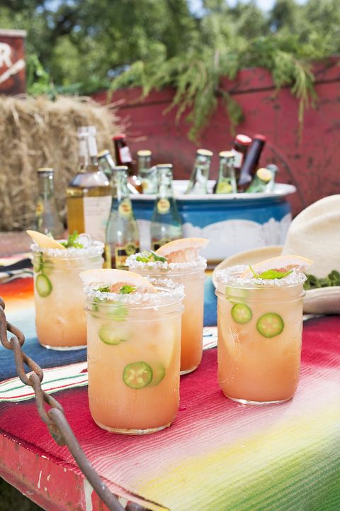 grapefruit ranch water in wide mouthed mason jars with salted rims and sliced grapefruit and jalapenos for garnish
