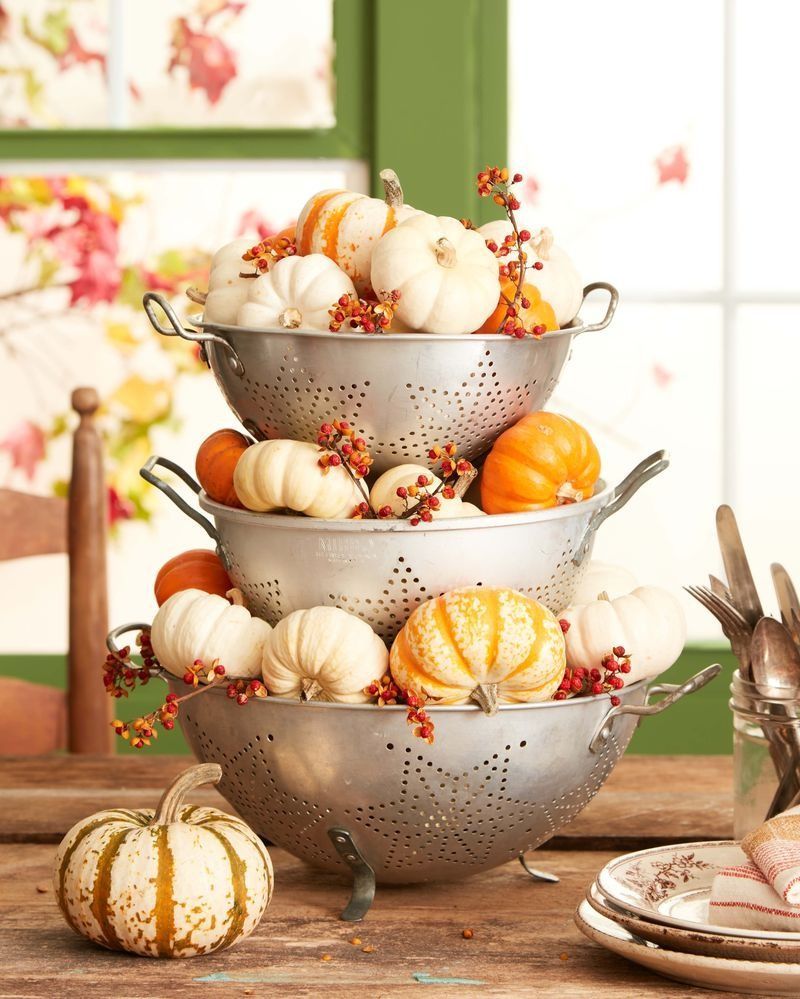 fall centerpiece made of vintage collanders and small pumpkin gourds