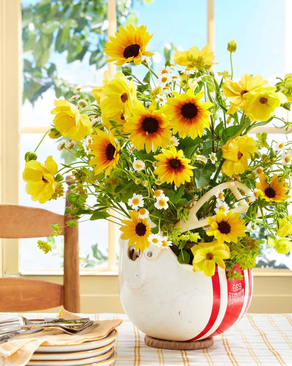 flowers arranged in a vintage football hemut infront of a window with blue sky