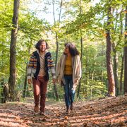 fall date ideas smiling couple walking through the woods