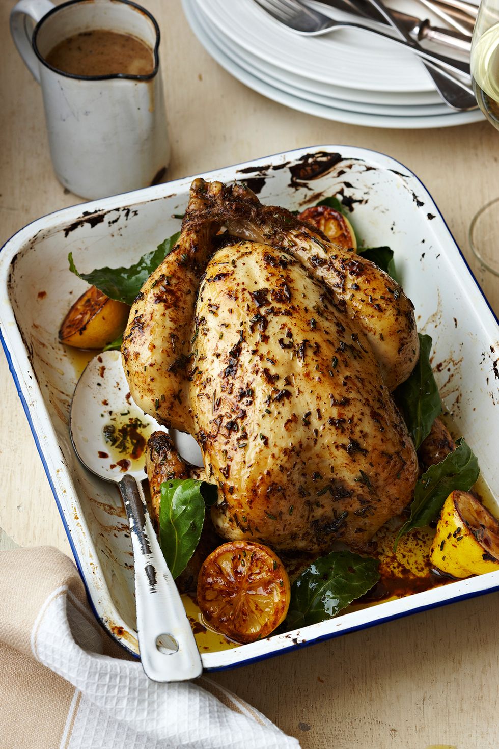roast chicken with lemon and basil in a white enamel tray