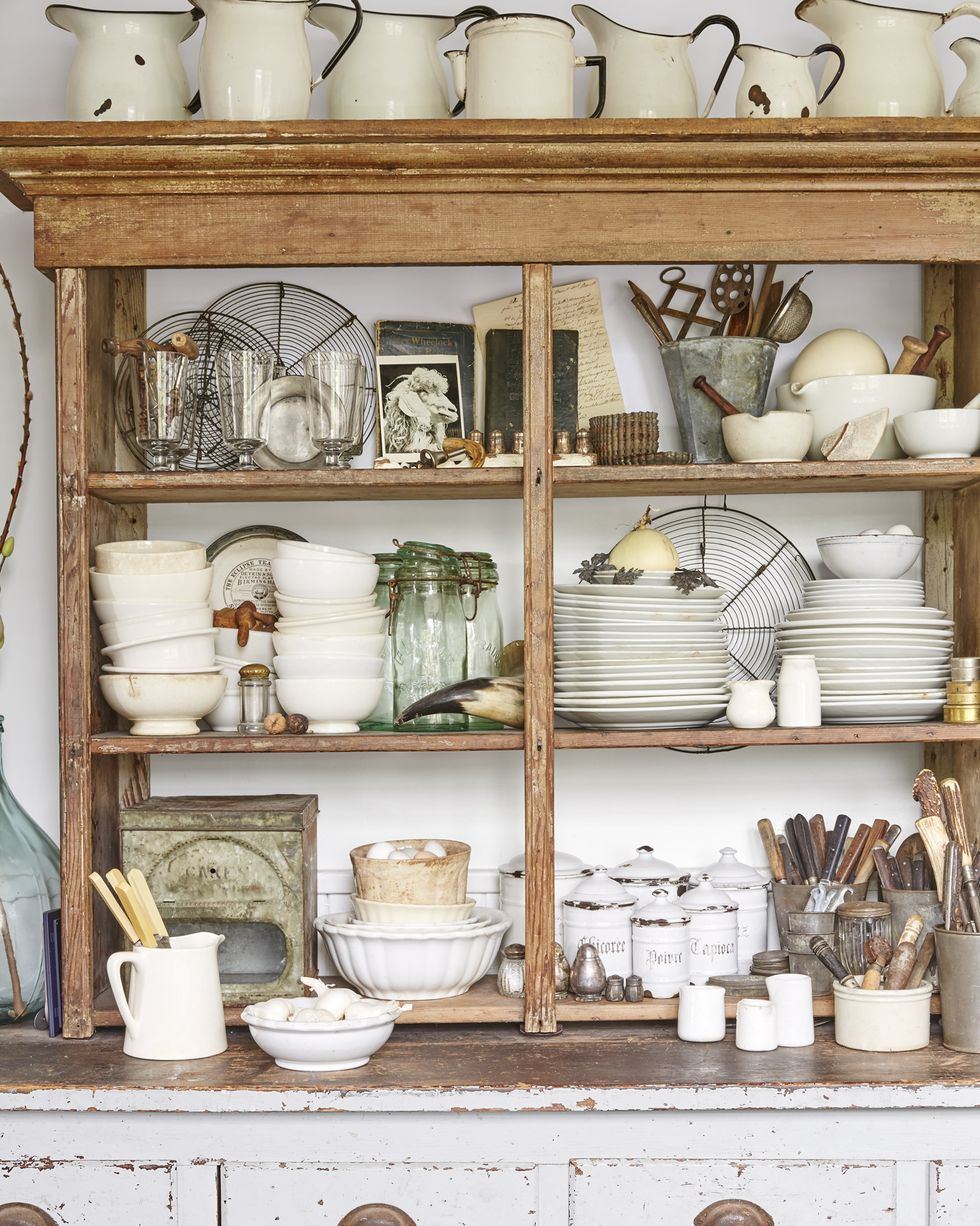 a rustic cabinet packed with stacks of ironstone dishware and other vintage collectibles