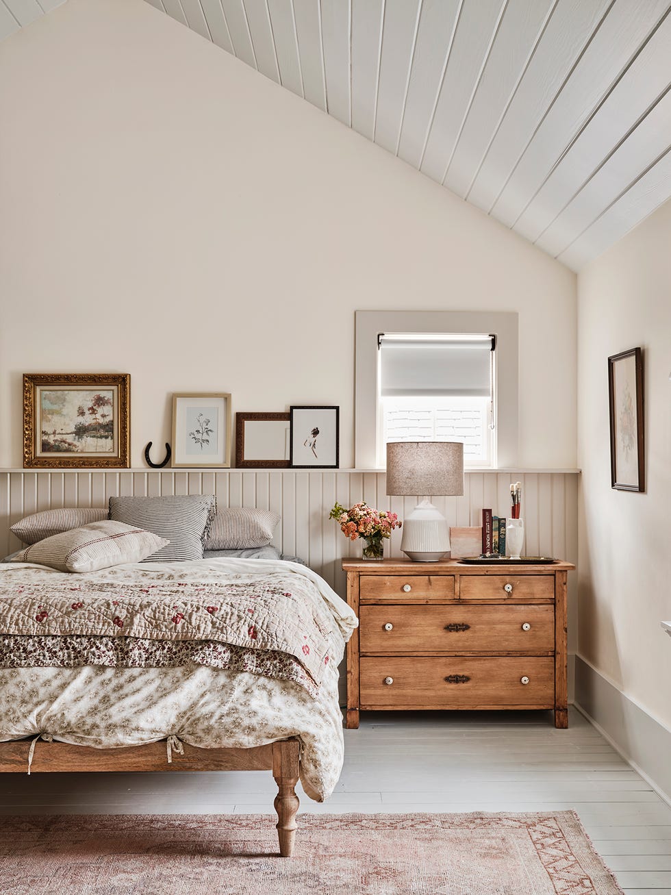 farmhouse bedroom with v groove paneling acting as a headboard and cozy patterned bedding in neutral colors