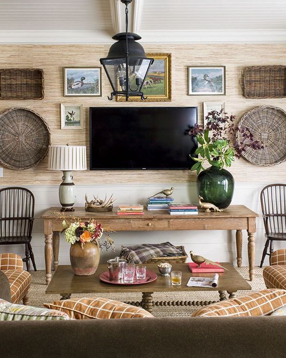 a mix of baskets and artwork and tv hang on a wall in a den