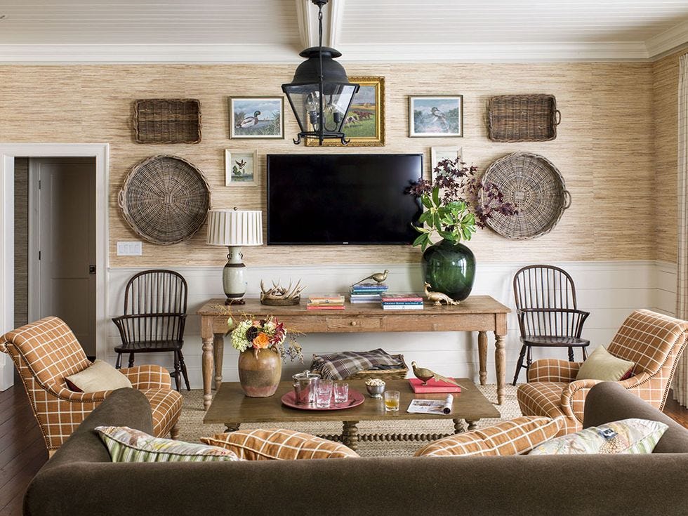 a mix of baskets and artwork and tv hang on a wall in a den