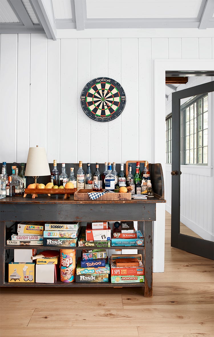 an old post office sorting table is used as a bar and filled with games on the lower level