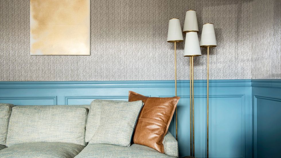 Blue study with textured wallpaper and gold art