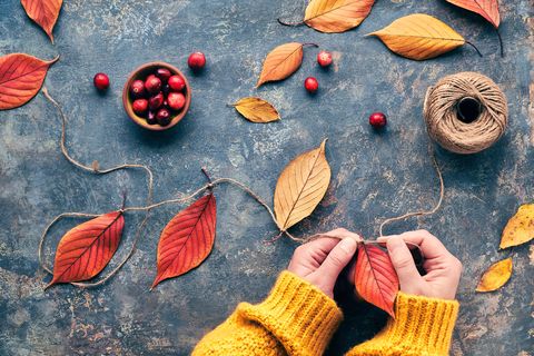 making garland with hemp cord and vibrant red autumn leaves