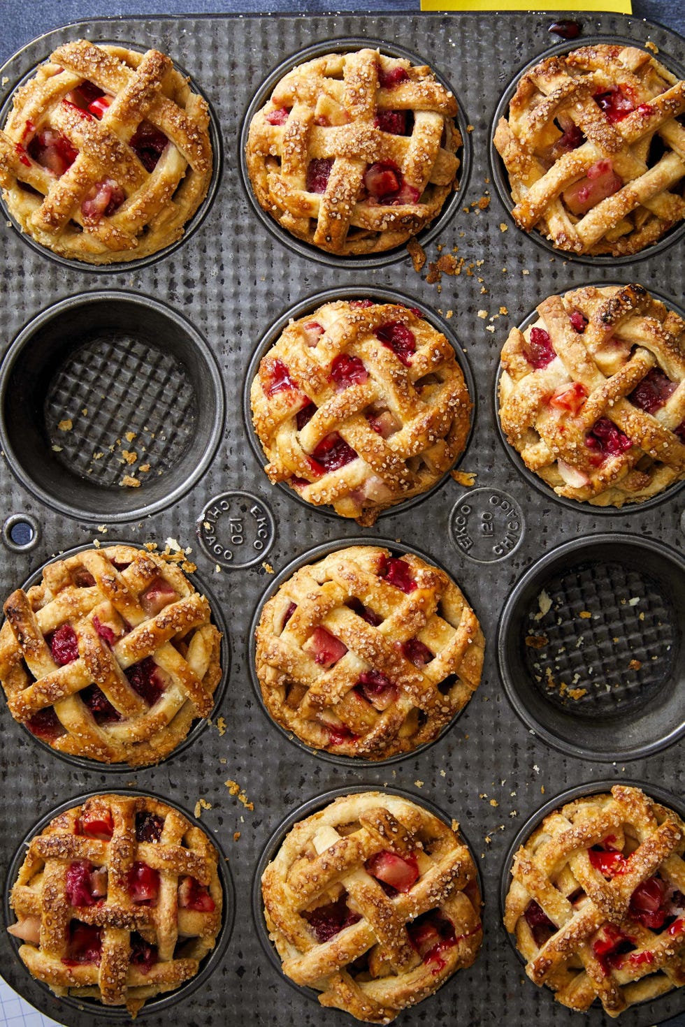 mini apple and raspberry pies in a muffin pan