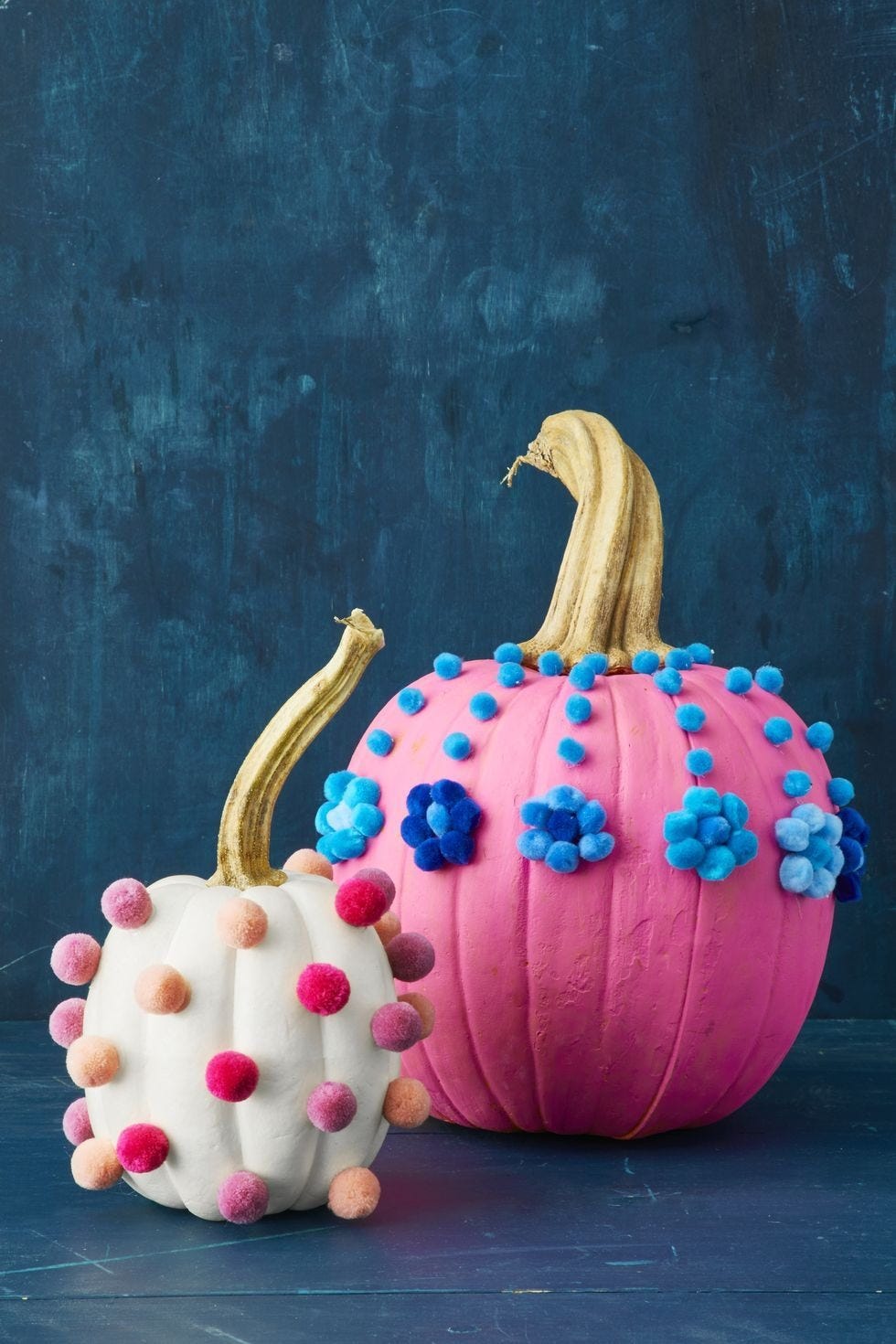 fall decor ideas, two pumpkins, one white and one pink decorated with pom poms