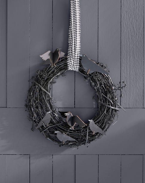 diy halloween crow wreath hung with black and white gingham ribbon