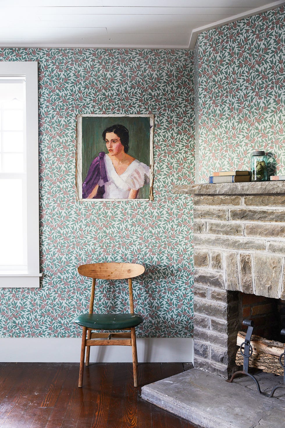 bedroom with wallpaper and stone corner fireplace