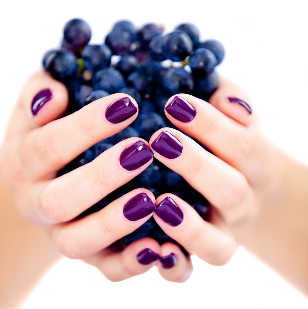 beautiful womans hand detail holding red grapes
