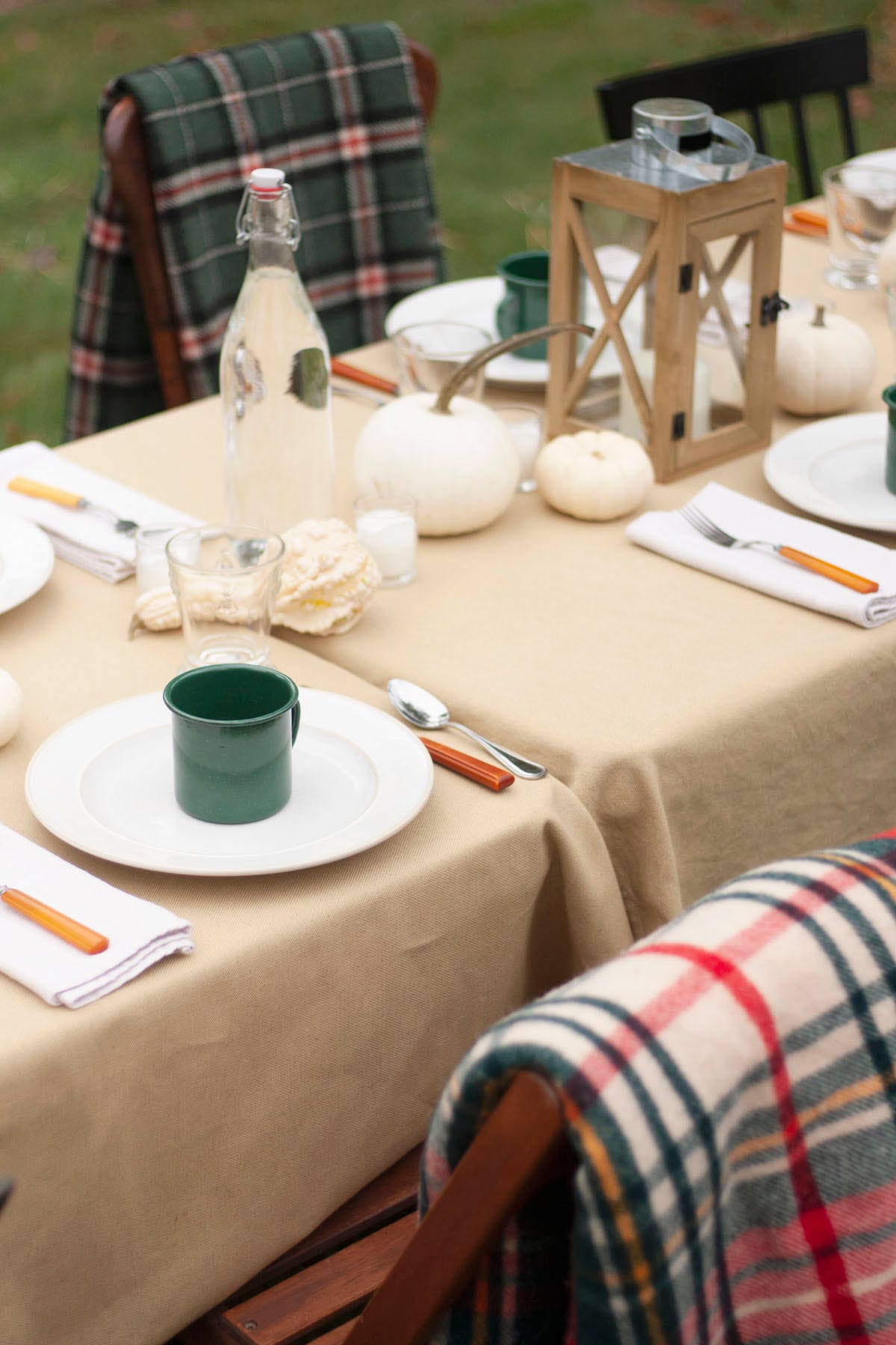 fall tablesetting with white plate, green mug, and white pumpkins