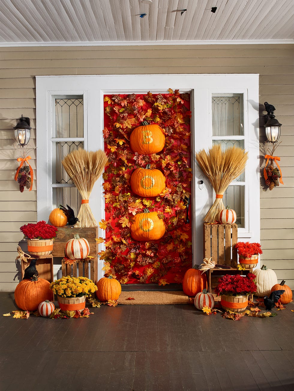 fall porch decor, decorated front door with leaves and pumpkins, surrounded by floors and pumpkins