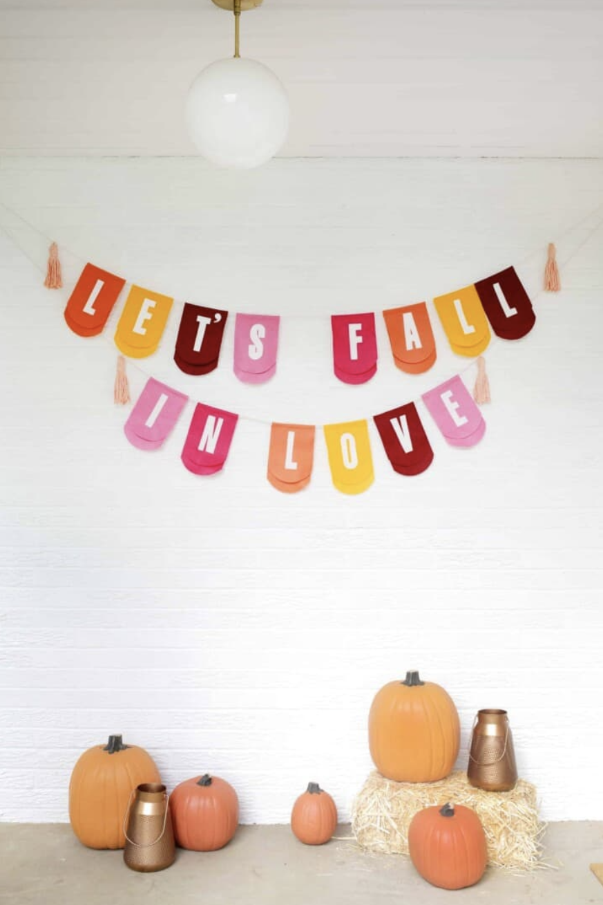 fall porch ideas, colorful garland with lets fall in love wording