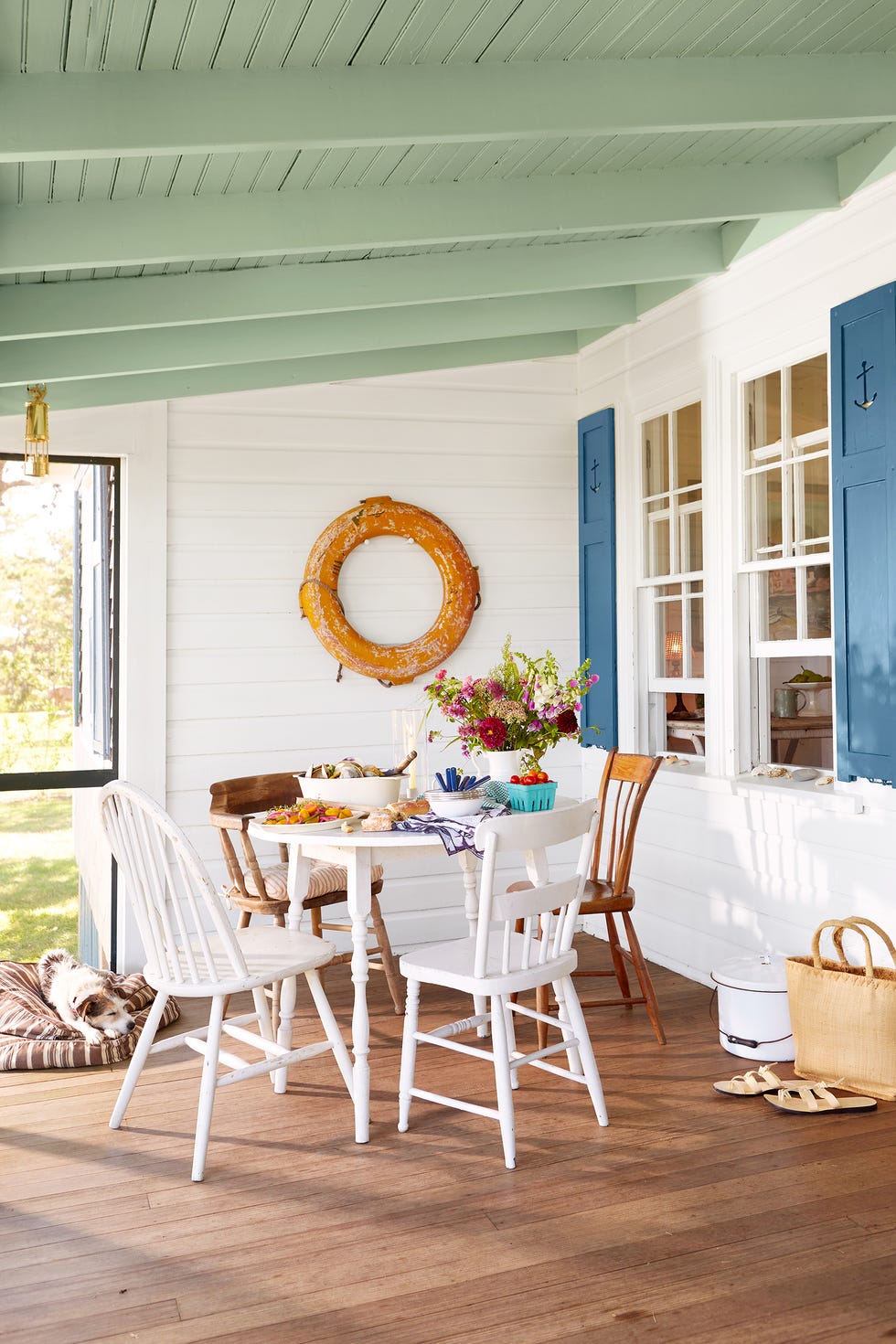 fall porch decor, round white table with mix match chairs on a porch
