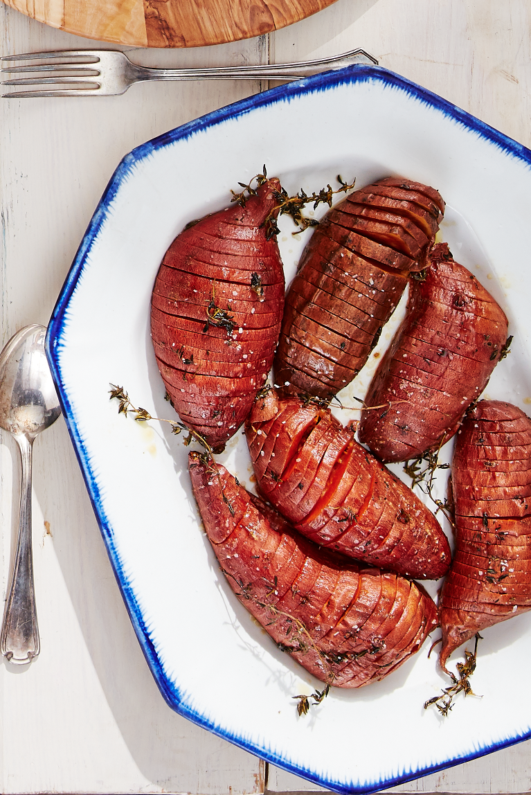 roasted hasselback sweet potatoes on a white serving plate