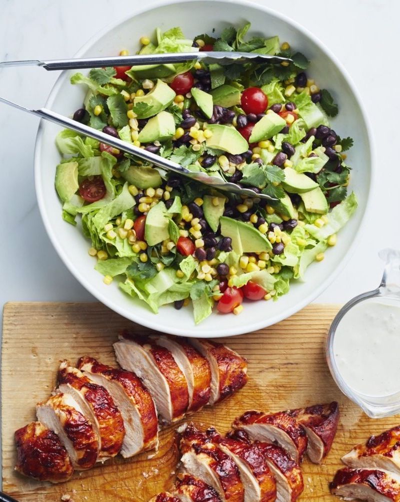 barbecue chicken salad with chicken on cutting board
