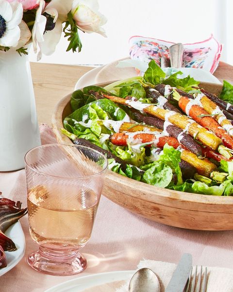 green salad with roasted carrots and creamy tarragon dressing in a wooden bowl