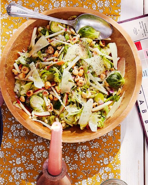 shaved brussels sprouts salad in a wooden bowl with a spoon for serving