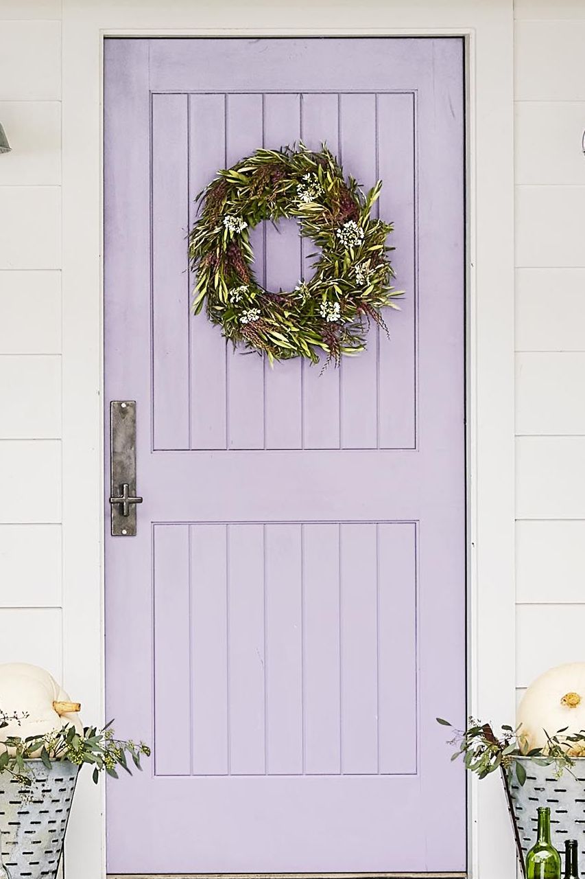 fall wreath of lush olive foliage and white statice flowers on a lavender front door
