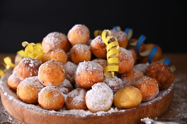 falling confetti on buns in powdered sugar traditional venetian carnival and food typical coffee, sfrappole or chiachiere or angel wings and aromatic coffee on a bright blue background