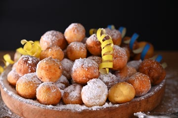 falling confetti on buns in powdered sugar traditional venetian carnival and food typical coffee, sfrappole or chiachiere or angel wings and aromatic coffee on a bright blue background