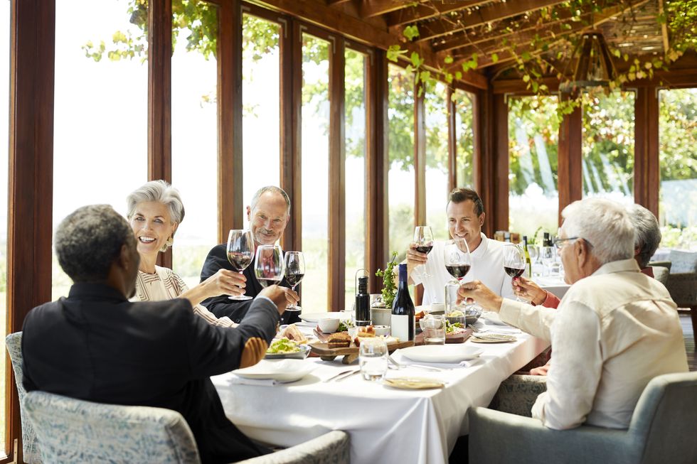 family and friends toasting red wine in restaurant