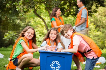 volunteers family cleans up their community park recycling bin