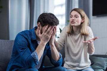 family conflict, quarrel, misunderstanding the woman shouts at her husband, in despair, crying requires explanation the man listens, covering his face with his hands sitting on the couch at home