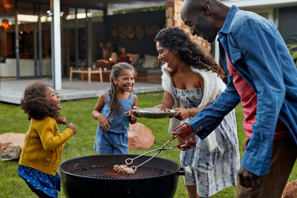 family cooking on grill in their garden