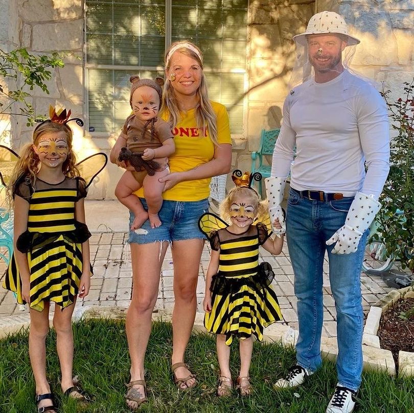 family costume idea for 5 with parents dressed as beekeeper and honey, 2 kids as bees, and baby as honey bear