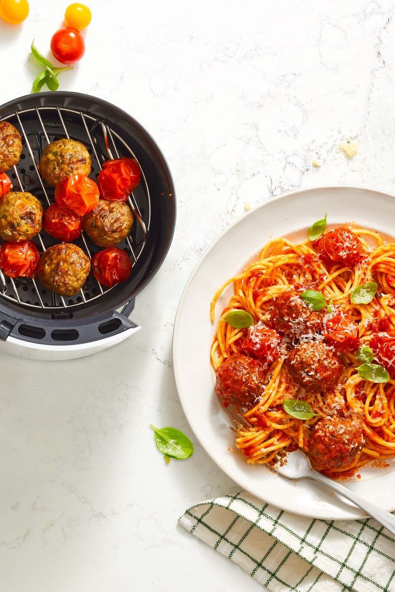 spaghetti and meatballs on a white plate