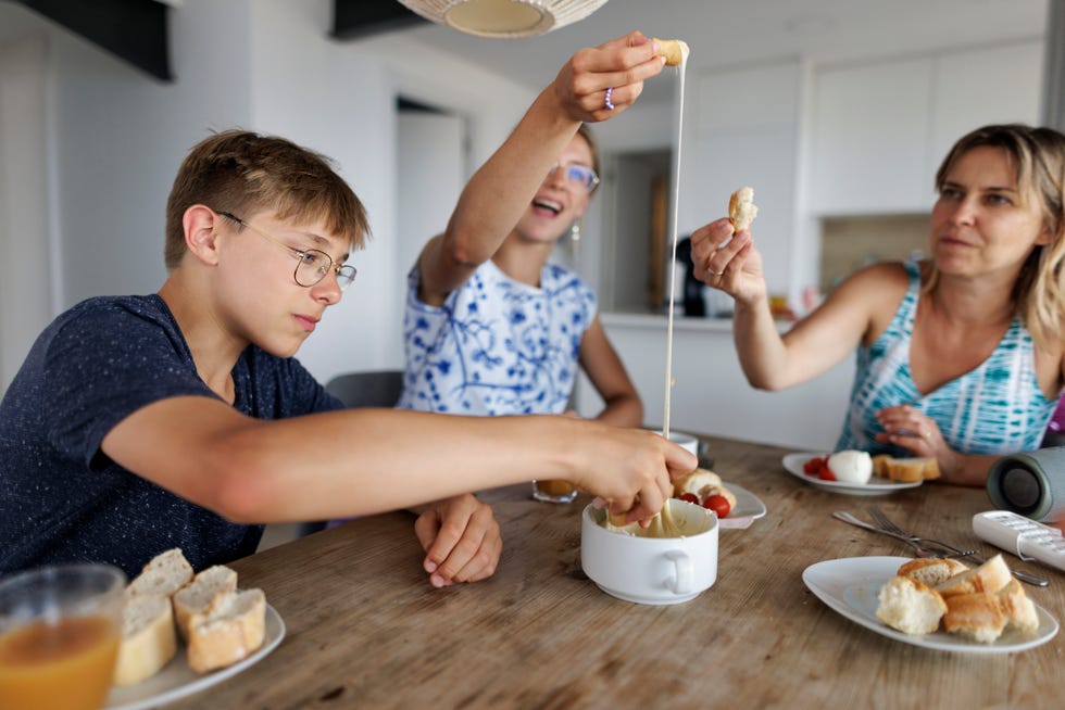 family enjoying fondue lunch at home