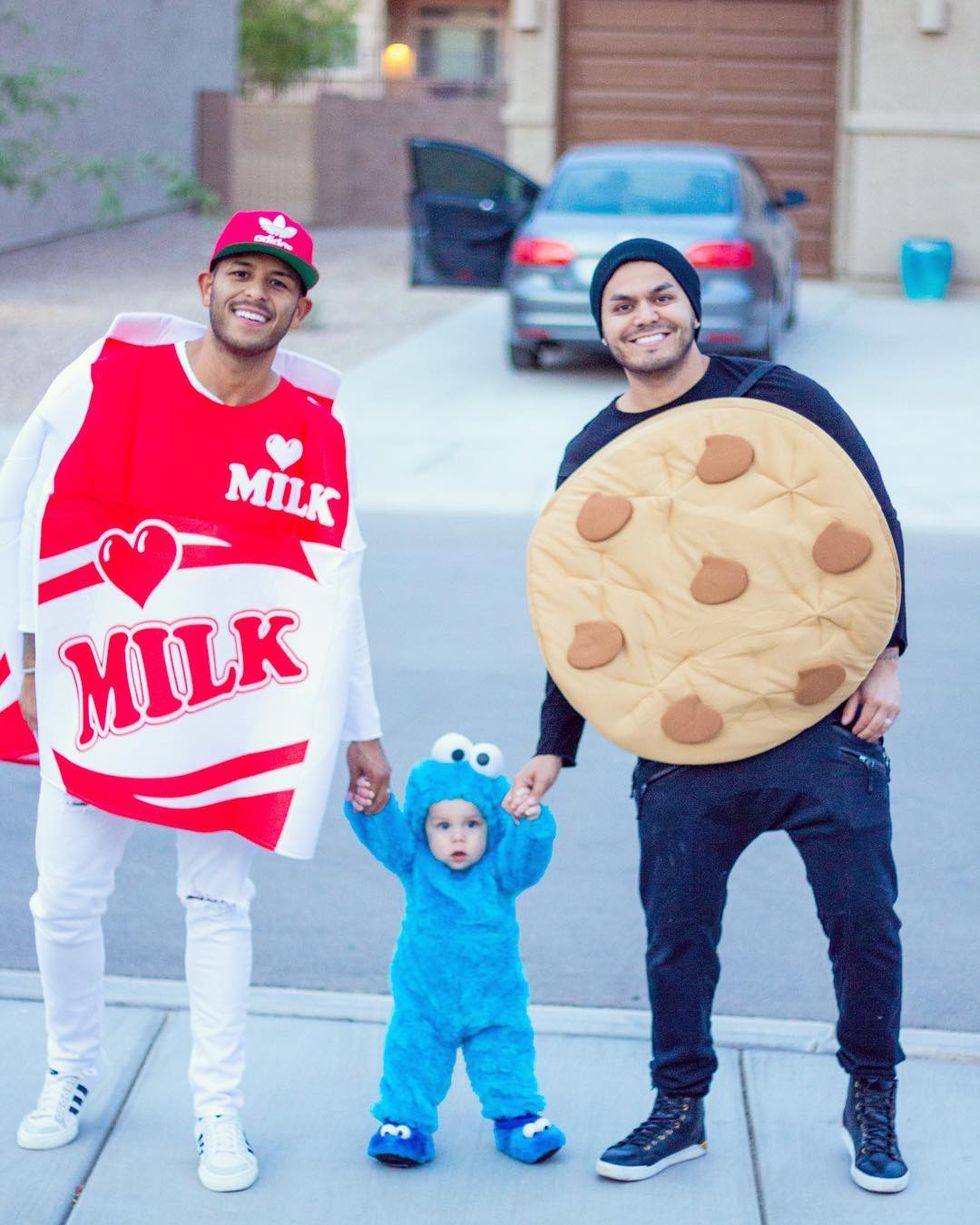 parents dressed as red carton of milk and chocolate chip cookie with child in blue cookie monster onesie for family costume