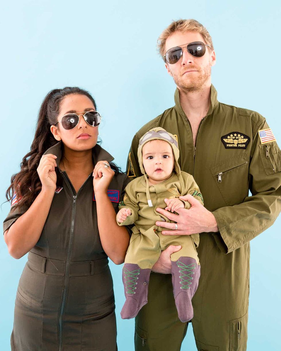 top gun family costume idea for 3 with parents and baby dressed in army green flight suits and aviator glasses