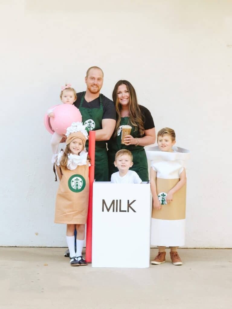 a family dressed in a starbucks group family halloween costume with kids dressed as a coffee, a latte, a milk box and a cake pop plus two parent baristas
